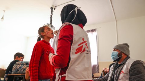 En kvinna i Läkare Utan Gränser väst ger en flicka ett oralt vaccin