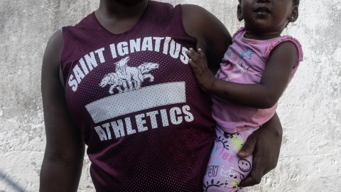 Halvkropp på kvinna som håller sitt barn i famnen.