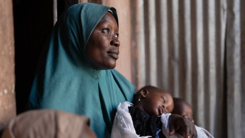 En mor håller sitt barn i famnen