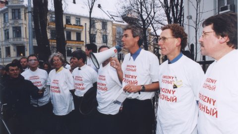 En grupp människor som har på sig vita t-shirtar. En man håller i en megafon
