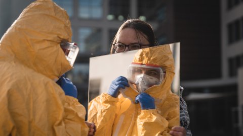 Anställd tar på sig en ebola-dräkt.