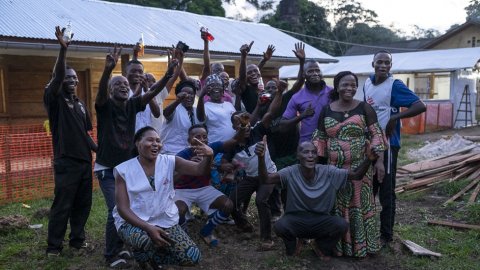En grupp människor håller upp armarna och ser glada ut