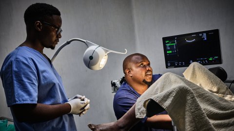 Medicinsk personal undersöker kvinna som ligger i gynstol.