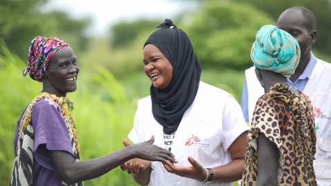 Personer i grupp kollar på varandra och skrattar