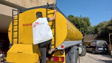 En medarbetare vid en lastbil med vatten.