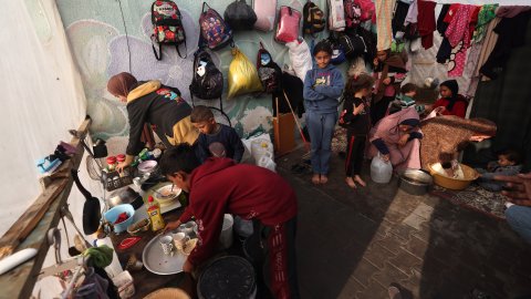 Personer står i ett tält fyllt av saker.