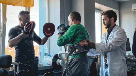 Patient står i ett rum och tränar boxning.