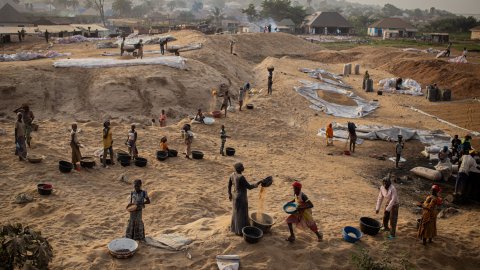 Vy över människor som arbetar på ett öppet fält.