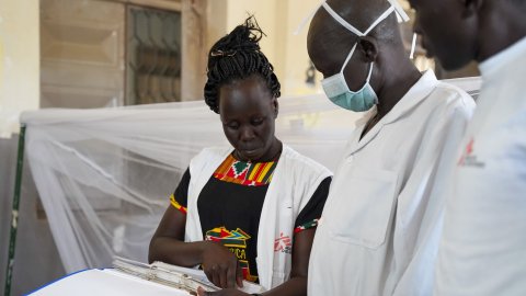 En kvinna visar två mån innehållet i en pärm