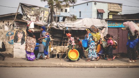 Människor på flykt som bär sina tillhörigheter på en gata i Goma