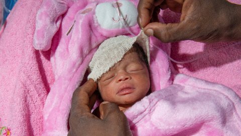 En nyfödd bebis i en rosa filt