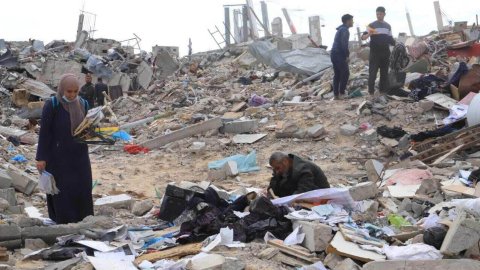 Grupper an vuxna och barn söker igenom rasmassor