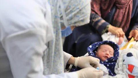 Vårdpersonal undersöker ett nyförlöst barn