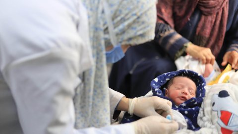 Vårdpersonal undersöker ett nyförlöst barn