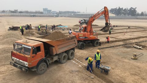 Lastbilar och grävmaskiner vid byggarbetsplats