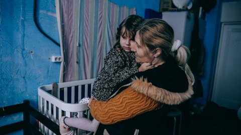 En kvinna med ett barn i famnen.