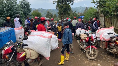 Ett gäng motorcyklar och människor med hjälmar mot natur.