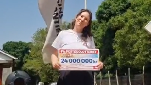 Felicia framför en Läkare Utan Gränser-flagga utomhus med en check där det står 24 miljoner