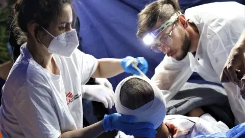 Vårdpersonal bandagerar en patients huvud.