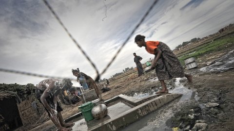 Internflyktingar tillhörande den diskriminerade och förföljda folkgruppen Rohingya hämtar vatten ur en pump i ett läger utanför Sittwe i Myanmar. 
