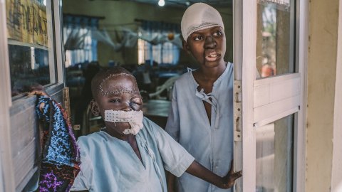 Åttaåriga Umar och femtonåriga Adamu står vid ingången till den postoperativa avdelningen på Sokoto sjukhus.