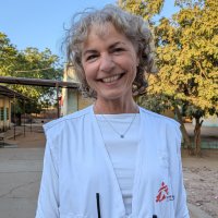 Kvinna tittar in i kameran och ler