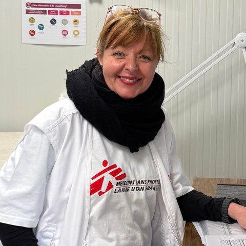 Kvinna tittar in i kameran och ler