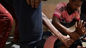 Flyktingar i Zintan, Libyen, försöker lugna en man som lider av psykiska besvär