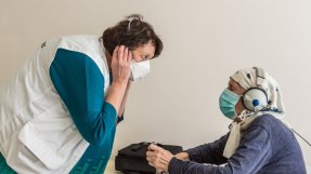En 78-årig kvinna få hjälp med ett hörseltest på ett tuberkuloscenter i Ukraina
