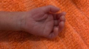 Ett barns hand i en filt