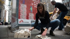 En kvinna på huk framför amerikanska låtsassedlar