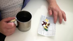 En patient med multiresistent tuberkulos visar upp sin dagliga dos mediciner.