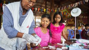 En läkare testar två patienter för malaria