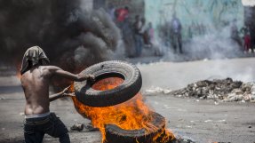 En demonstrant bränner däck i Port-au-Prince