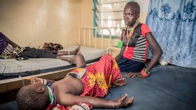 En flicka som blivit ormbiten ligger på en brits på ett sjukhus i Kenya, hennes mamma sitter bredvid och tittar in i kameran. 