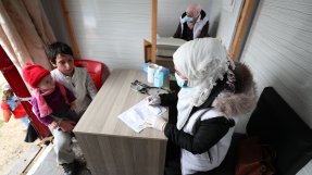 En sjuksköterska konsulterar med en ung pojke i nordvästra Syrien