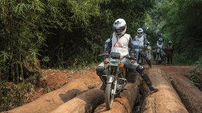 Sjukvårdspersonal på motorcyklar på en lerväg