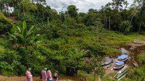 Personal påväg till båtar för transport i Amazonas regnskog