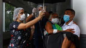 En kvinna med covid-19 bärs till ambulans för vidare transport till flygplatsen och därifrån till sjukhuset i Manaus, Brasilien. 