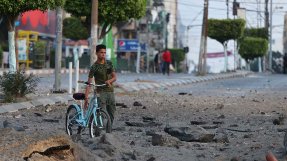 En palestinsk man i närheten av al-Sharouk tornet i Gaza, som inrymde TV-kanalen al-Aqsa, som förstördes i en israelisk flygattack, i Gaza City, den 13 maj.