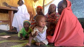 Mabola, här med sin åtta månader gamla son Ahmad som lider av öroninfektion, väntar på vår klinik i byn Dilli, Sudan.