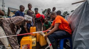 Människor fyller på sina dunkar med rent dricksvatten vid en av våra distributionsplatser i Sake, Kongo-Kinshasa.