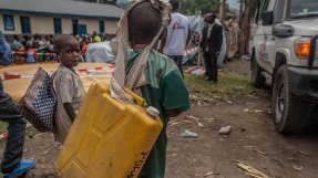 Ett barn i Sake bär på en vattendunk, efter vulkanen Nyiragongos utbrott i Kongo-Kinshasa