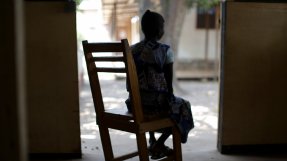 En kvinna i Centralafrikanska republiken sitter i en gungstol med ryggen mot kameran.