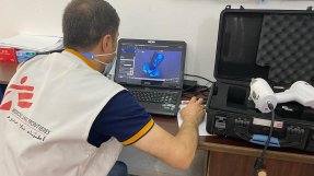 En anställd från Läkare Utan Gränser vid en 3D skrivare i Gaza, Palestina.