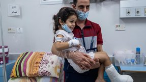 Fembarnspappan Mohammed Aboud bär sin fyra år gamla dotter Hala som har gips på höger fot, på al-Awda sjukhus i norra Gaza, Palestina. 