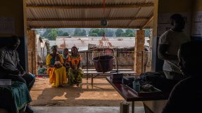Innifrån en vårdcentral i byn Nzacko, Centralafrikanska republiken. Utanför sitter tre kvinnor på en bänk och väntar på sin tur.