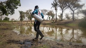 En anställd på Läkare Utan Gränser går vid en vattensamling