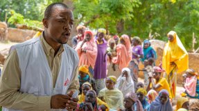 Sjuksköterskan Malik förklarar för invånarna i en by i Niger vad det innebär att vara hälsorådgivare.