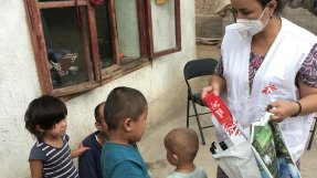 En medarbetare från Läkare Utan Gränser delar ut leksaker till barnen Zainidin och Bibisoleha som är sjuka i tuberkulos. 